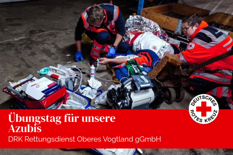 Zwei Azubis versorgen, im Rahmen der Übung, einen Verletzten vor einem Hochregal.